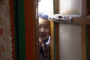 Enfant mongol qui regarde par la porte